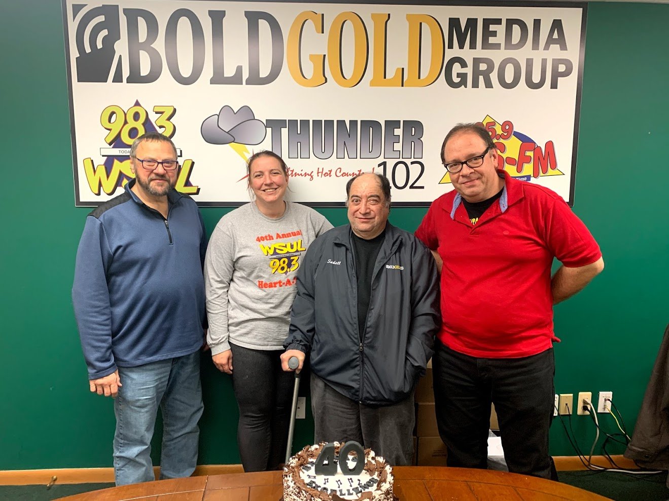 Bold Gold Media radio personalities Paul Ciliberto of Thunder 102, left, Jenn Desrochers of WSUL, Mike Sakell and Eddie Wilson of WVOS celebrate Sakell's 40th year in broadcasting with a cake. Sakell has inherited the title, "the Voice of Sullivan County."